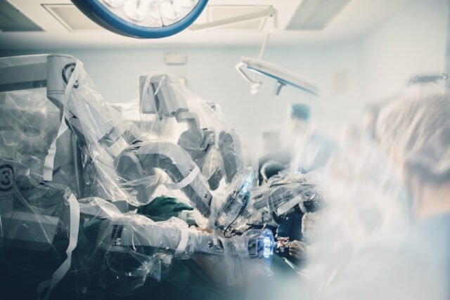 Cirurgia Robótica e Educação Médica 2 Sala cirúrgica em hospital com equipamentos de tecnologia robótica, cirurgião com braço mecânico em sala de cirurgia futurista. Robô médico cirúrgico minimamente invasivo, cirurgia urológica com cirurgião assistido por robô.